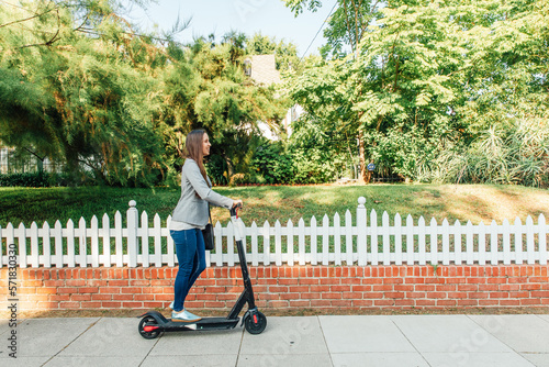 Woman Rides Scoot on Sidewalk photo