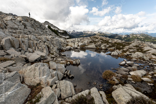 A man takes in the view of the mountains he is hiking in. photo