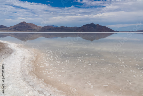 Panoramic view of beautiful mountains reflecting in lake of Bonneville Salt Flats, Wendover, Western Utah, USA, America. Looking at summits of Silver Island Mountain range. West of Great Salt Lake photo