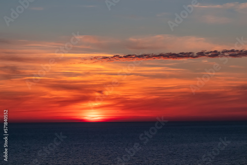 Panoramic sunset view from Sveti Stefan at Adriatic Mediterranean Sea, Budva Riviera, Montenegro, Europe. Reflection of sun beams on water surface during twilight. Summer vacation in seaside resort