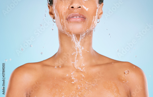 Face, water and cleaning with a black woman in studio on a blue background for hygiene or hydration. Splash, shower and bathroom with a young female washing her body for natural skincare or wellness