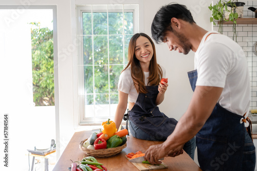 Happy Asian couple preparing food to cook breakfast in the kitchen And have fun cooking.