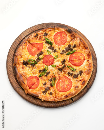 Pizza slice with tomatoes, cheese and minced meat. Pizza is cut into slices on wooden board. Italian Cuisine. Fast food. Isolate on white background. Close-up. Top view. Copy space. 