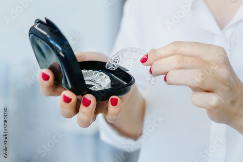 woman holding removable invisible aligner