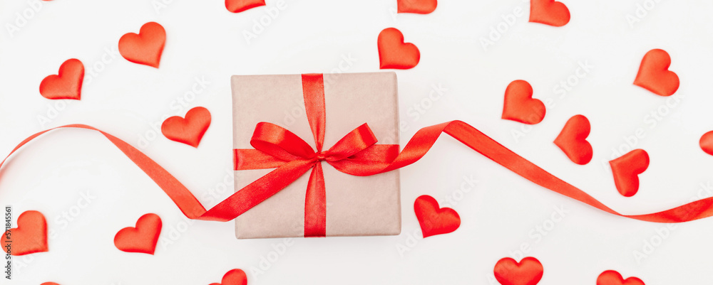 Baner Hearts gift box with a red bow on a white background with red hearts. Festive web banner. View from above. Baner Hearts gift box with a red bow on a white background with red hearts. Festive web banner. View from above.