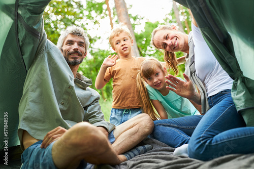 Man and woman setting up tent with children