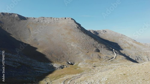 Drone Video of Mountain Peaks Mount Olympus Greece in the morning on a sunny day, dirt road in the distance photo