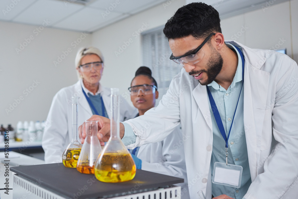 Science, chemistry and team with liquid for medical research, study and vaccine development. Biotechnology, pharmaceutical and scientists with sample in glass beaker for analysis, test and experiment Science, chemistry and team with liquid for medical research, study and vaccine development. Biotechnology, pharmaceutical and scientists with sample in glass beaker for analysis, test and experiment
