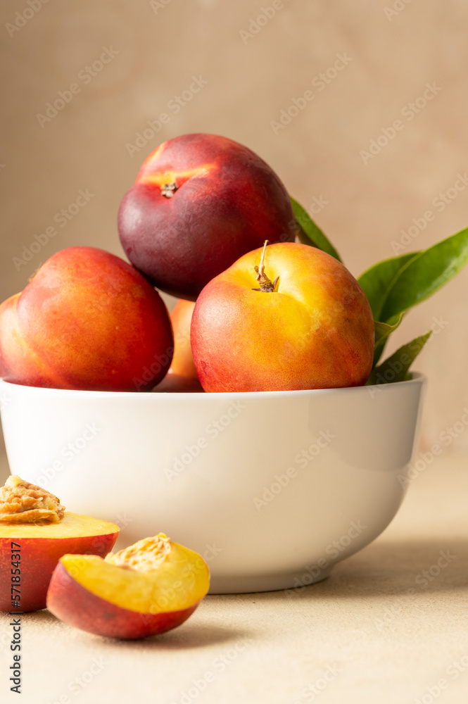 Fresh nectarine peaches fruits in a bowl. Neutral background.Summer foods. Fresh nectarine peaches fruits in a bowl. Neutral background.Summer foods.