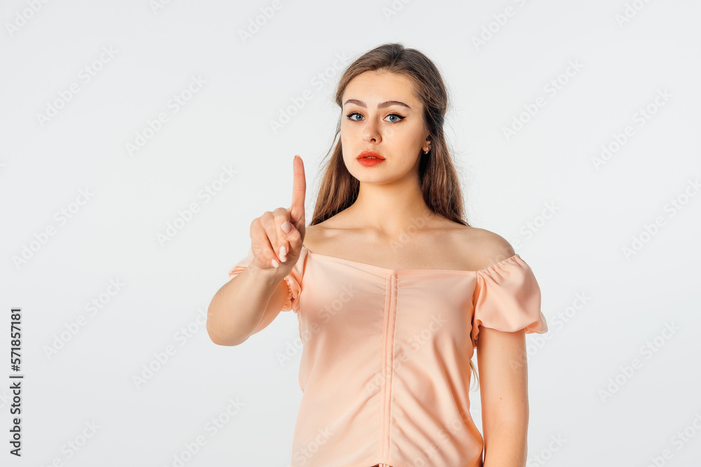 Young woman frowns and looks very dissatisfied, shake forefinger telling no way, scolding or telling off someone, dont give permission, stands over white background Young woman frowns and looks very dissatisfied, shake forefinger telling no way, scolding or telling off someone, dont give permission, stands over white background