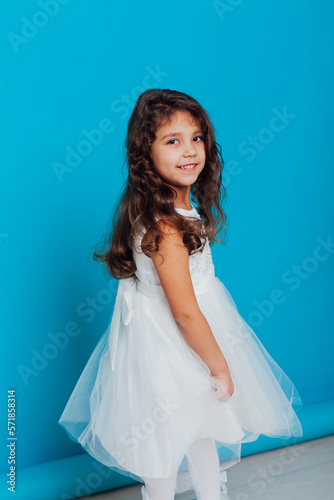 little girl in a white dress on a blue background