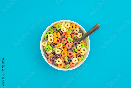 Colored breakfast cereals laid out in a bowl on a blue background, top view, children's healthy breakfast.