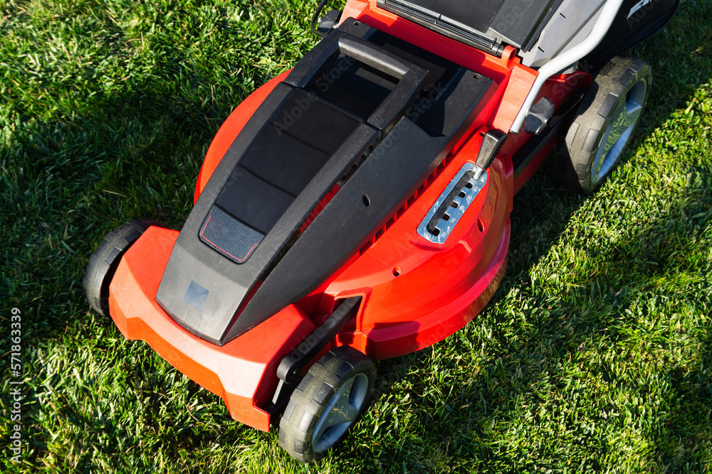 Electric Lawn mower on a green meadow. Garden equipment Electric Lawn mower on a green meadow. Garden equipment