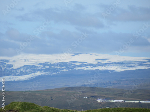 Hills and a glacier in Iceland with grey clouds