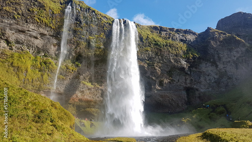 People walking behind Seljalandsfoss waterfall in Iceland