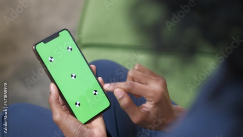 A black woman with a smartphone in her hand. Shooting from the back. A set of tap gestures on the touchscreen. Officework. The concept of a successful business woman, feminism. Close-up. Green screen.