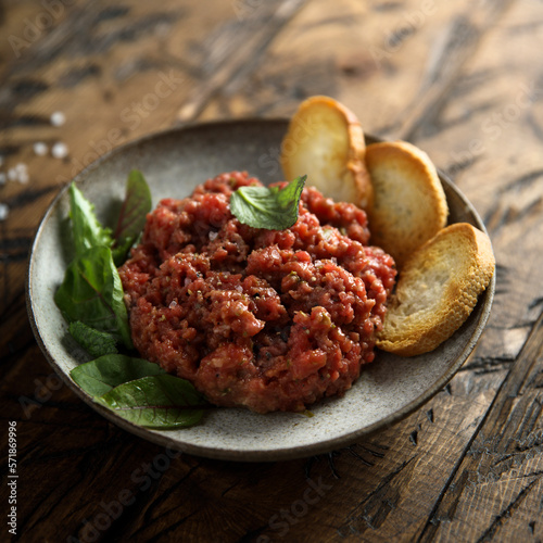 Quadro su tela Homemade steak tartare with baguette bread