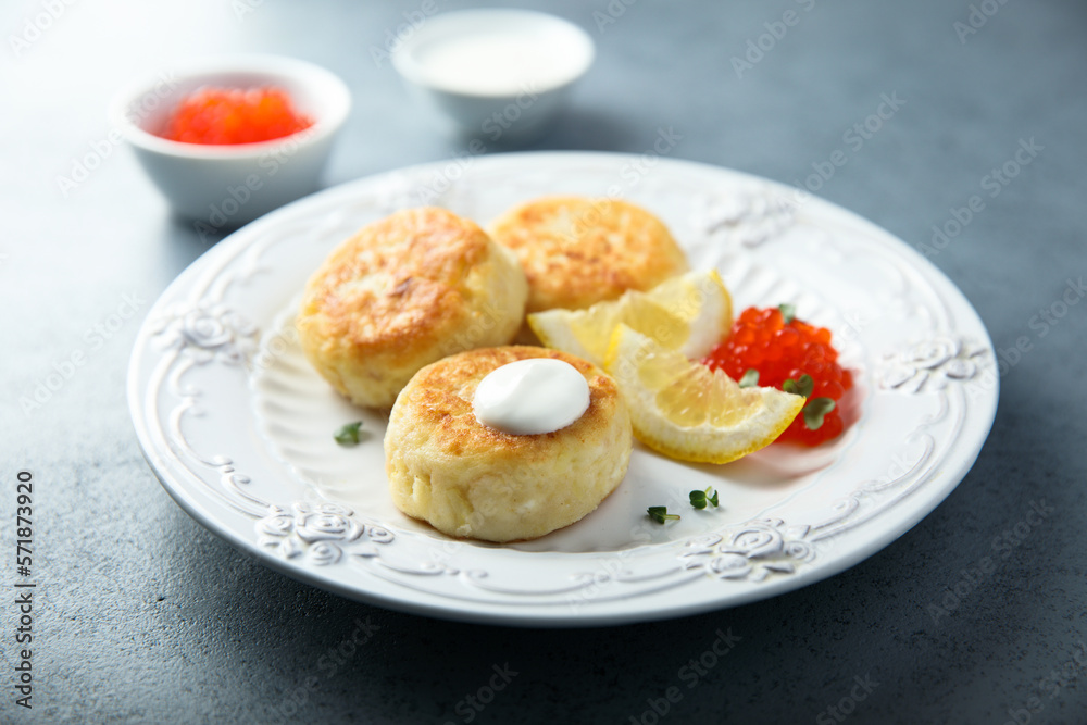 Homemade potato cakes with red caviar and lemon Homemade potato cakes with red caviar and lemon