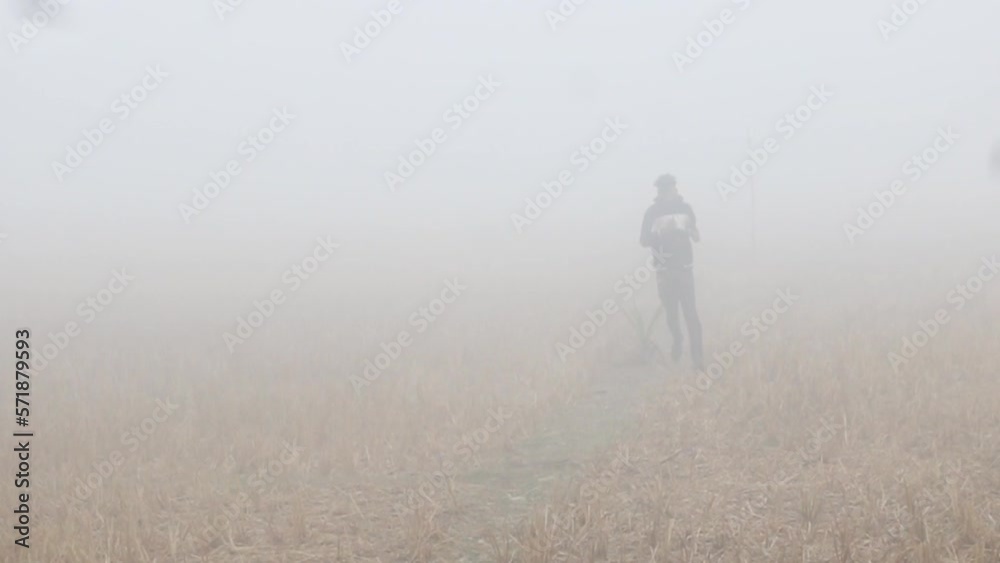 Young Indian man jogging in a foggy field. Concepts of outdoor sport and health in a polluted country. Young Indian man jogging in a foggy field. Concepts of outdoor sport and health in a polluted country.