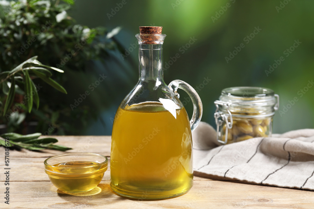 Jug and bowl of olive oil on wooden table. Healthy cooking Jug and bowl of olive oil on wooden table. Healthy cooking