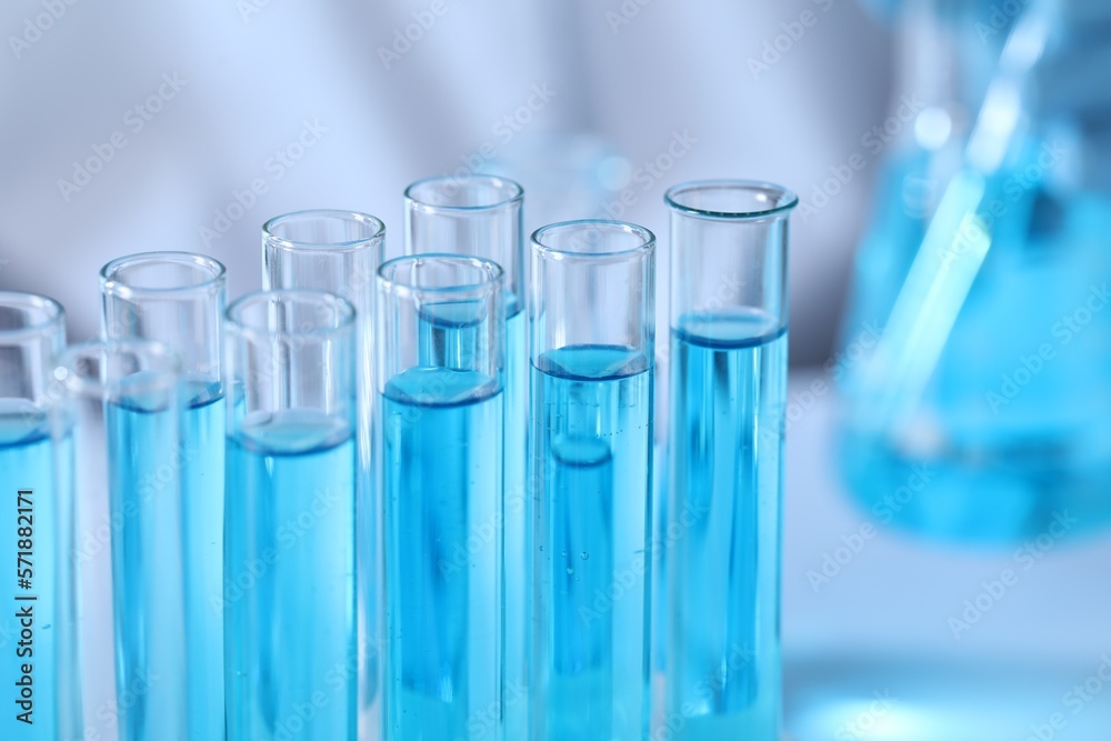 Test tubes with light blue liquid in laboratory, closeup Test tubes with light blue liquid in laboratory, closeup