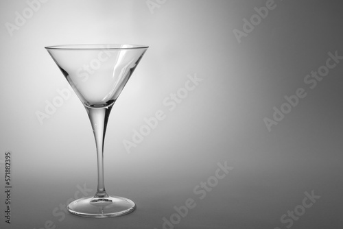 Elegant empty martini glass on grey background. Space for text
