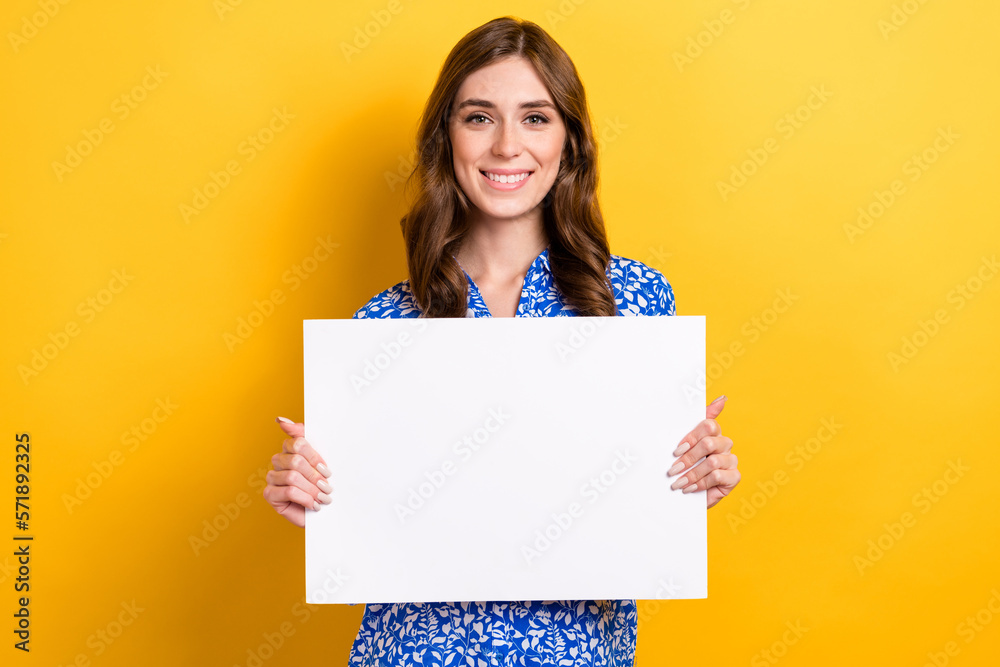Photo of sweet cheerful woman dressed blue blouse holding white placard empty space isolated yellow color background Photo of sweet cheerful woman dressed blue blouse holding white placard empty space isolated yellow color background