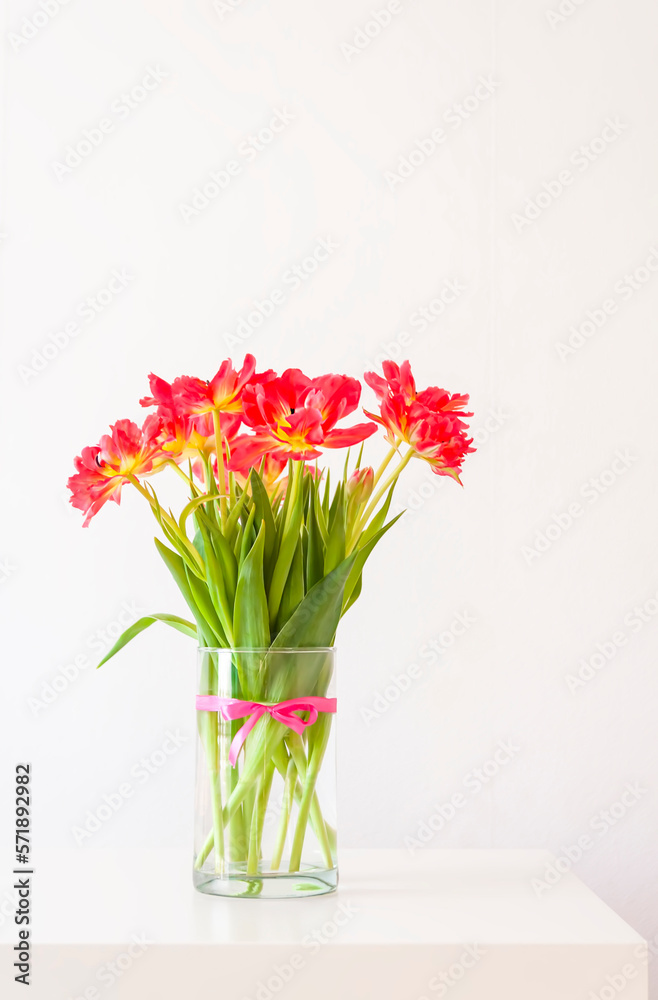 Red tulips. Beautiful flowers in a vase on soft light background.