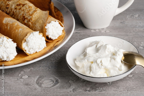 Sour cream and thin pancakes with cottage cheese. Healthy traditional breakfast concept
