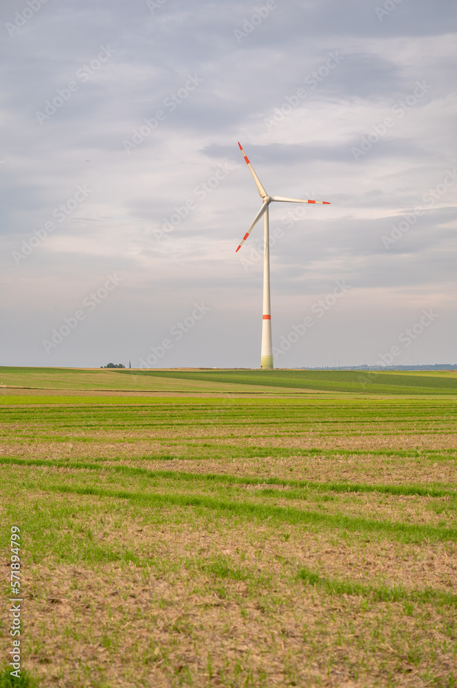 Wind turbine with agricultural field in front during cloudy day, mainz, germany, vertical shot Wind turbine with agricultural field in front during cloudy day, mainz, germany, vertical shot