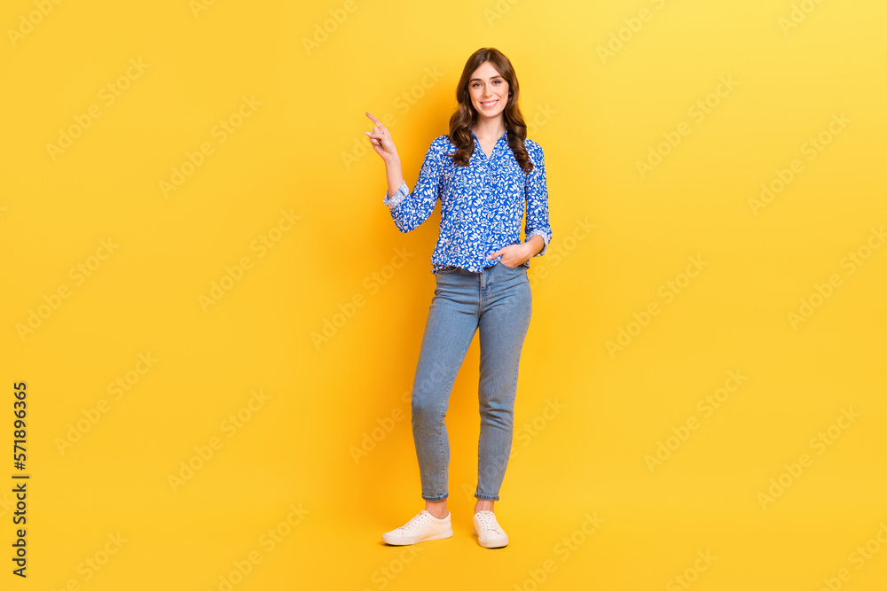 Full size photo of cheerful pretty girl indicate finger empty space proposition isolated on yellow color background Full size photo of cheerful pretty girl indicate finger empty space proposition isolated on yellow color background