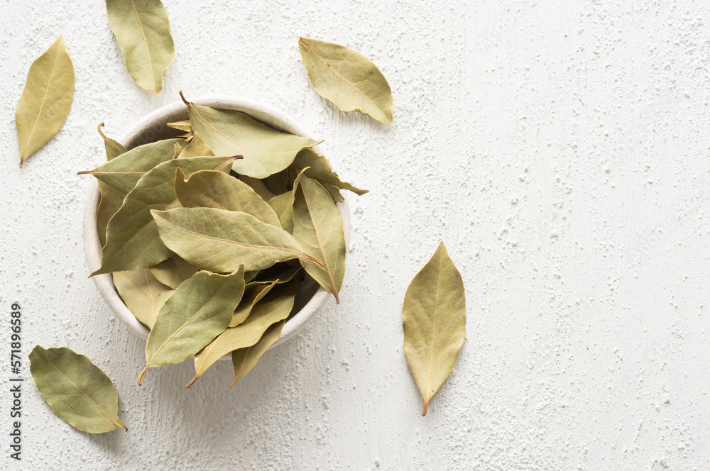 Dried bay leaves in bowl on rustic background, Spices and herbs concept (Laurus nobilis) Dried bay leaves in bowl on rustic background, Spices and herbs concept (Laurus nobilis)