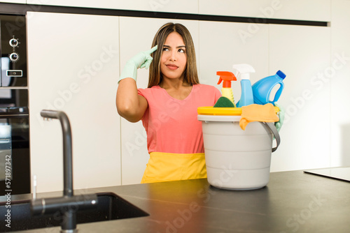 pretty latin woman. housekeeper with clean products.