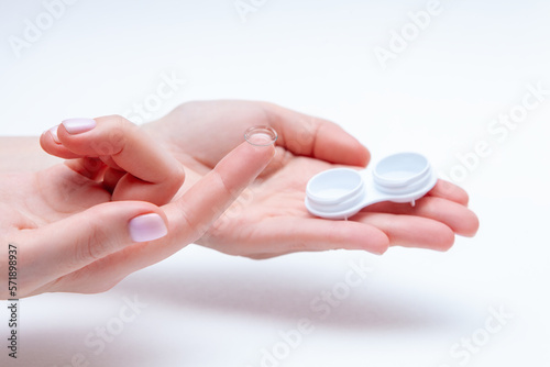 Contact Eye Lenses. Woman Hands Holding Contact Eye Lens. Woman Hands Holding White Container. Beautiful Woman Fingers Holding Eye Lens Box