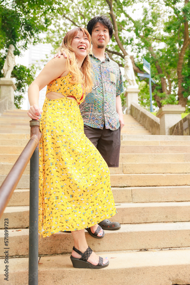 Naklejka premium 階段の手すりに寄り添い肩を並べる男女