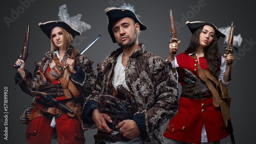 Studio shot of crew of corsair man and two female pirates looking at camera. © Fxquadro
