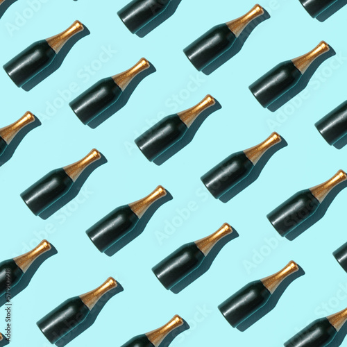 Champagne bottles, creative pattern, summer party concept, pastel blue background. 