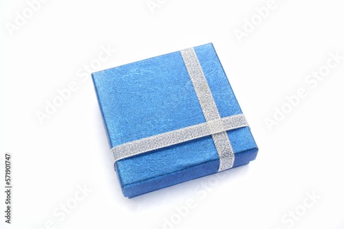 Blue gift box with silver ribbon on white background. Wedding, birthday, Valentine's Day, Mother's Day, Women's Day concept. Idea for congratulation, invitation, greeting card. Flatlay, top view