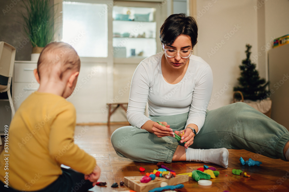 Mother and son molding a clay at home and having educational act Mother and son molding a clay at home and having educational act
