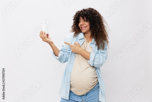 Pregnant woman smile with teeth jar of pregnancy vitamin pills in hands, alpha lipoic acid, vitamin complex on white isolated background copy space © SHOTPRIME STUDIO
