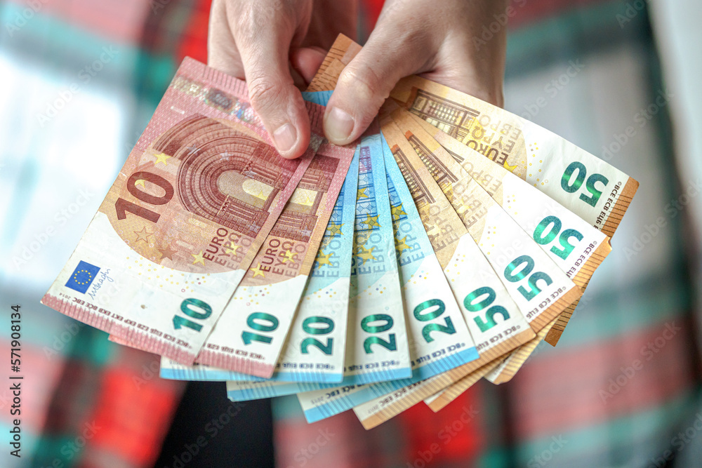 Woman holding many Euro banknotes of different value