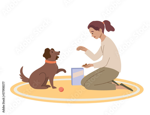 Girl gives friendly dog a treat. The owner trains pet to give a paw.