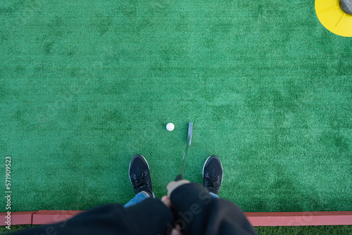 Top view of a unrecognizable golfer playing miniature golf