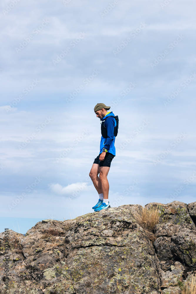 Young man practising trail running on a mountain top, copy space. Young man practising trail running on a mountain top, copy space.