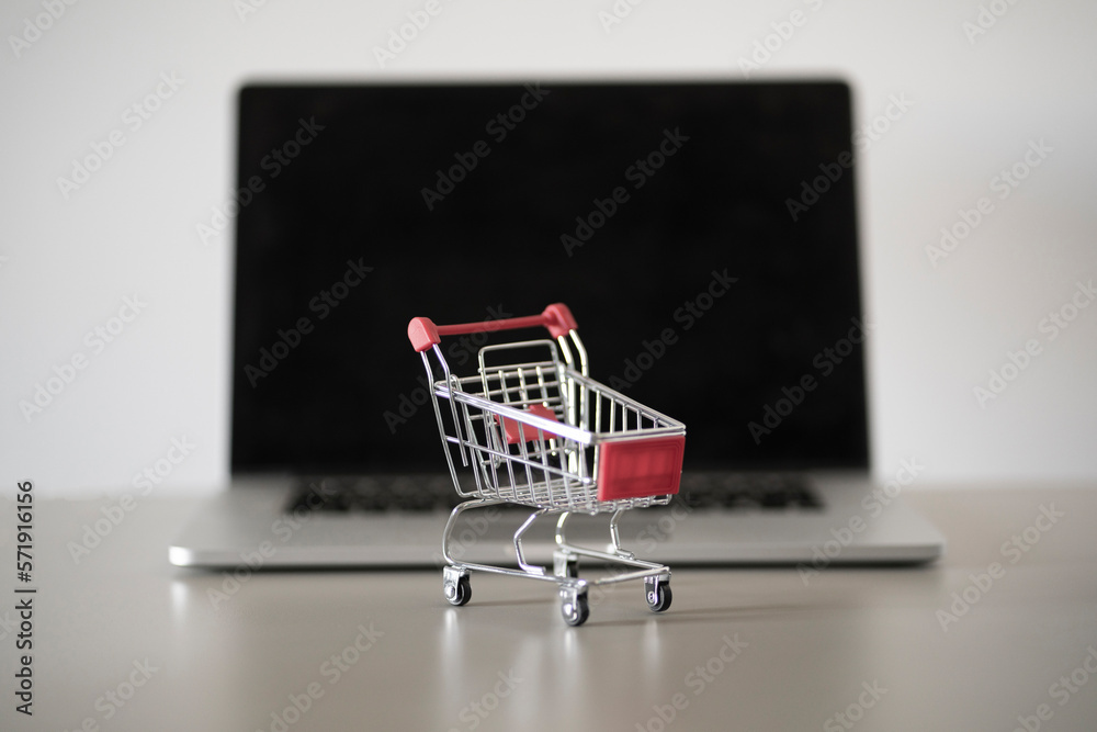 empty shopping cart near the laptop, online shopping, e-commerce