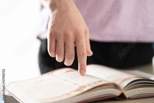 reading book and getting knowledge, hand pointing on the text in book