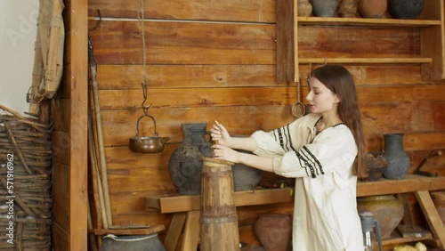 Wallpaper Mural A young woman is churning butter with a wooden churn. An old house Torontodigital.ca