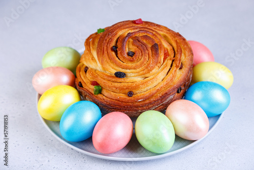 Craffin (Cruffin) with raisins and candied fruits. Traditional Easter Bread Kulich and painted eggs on a gray background. Easter Holiday. Close-up, selective focus. photo