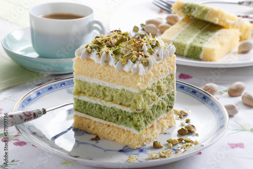 Mini cake layered with cream and pistachio sprinkles photo
