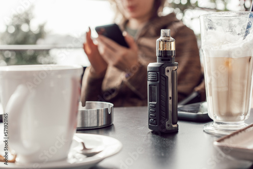 Photos Vape stands on a wooden table in cafe